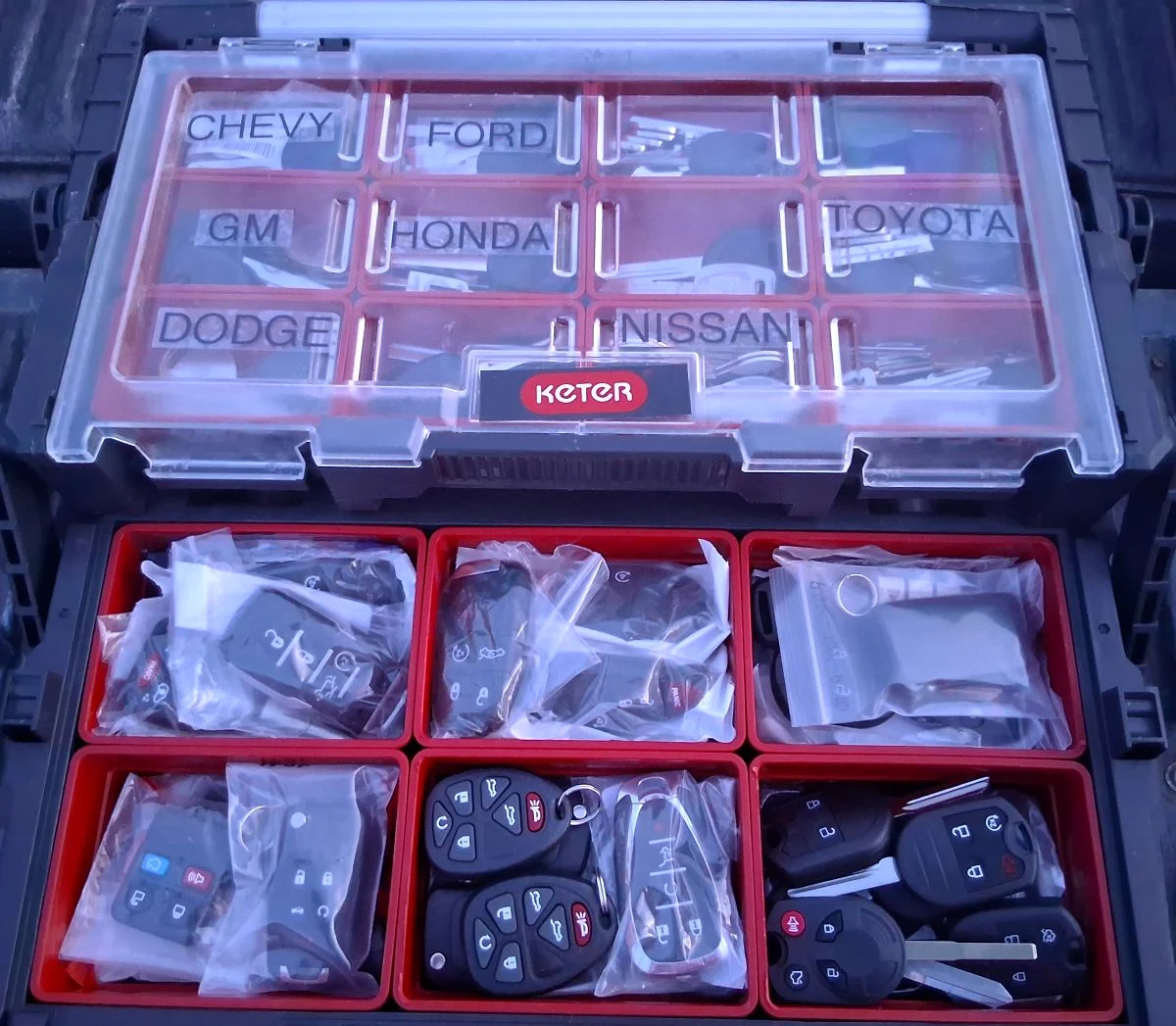 Stocked case of automotive keys and remote fobs organized by vehicle make